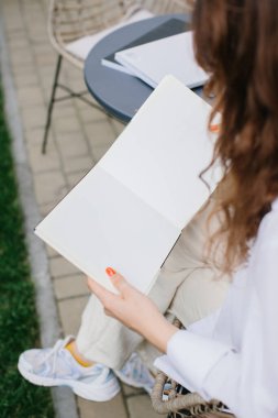 Mockup image dergisi kitabı. Kahve masasında dergi okuyan kız..