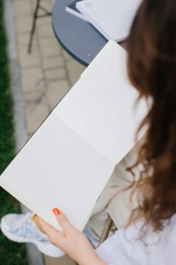 Mockup image dergisi kitabı. Kahve masasında dergi okuyan kız..