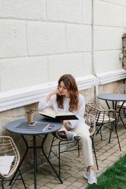 Mockup image dergisi kitabı. Kahve masasında dergi okuyan kız..