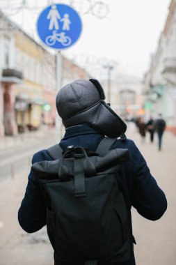 Kış şehrinde hafta sonları yürüyüş yapan kıdemli bir adam. Şehir hayatı ve eğlence kavramı..