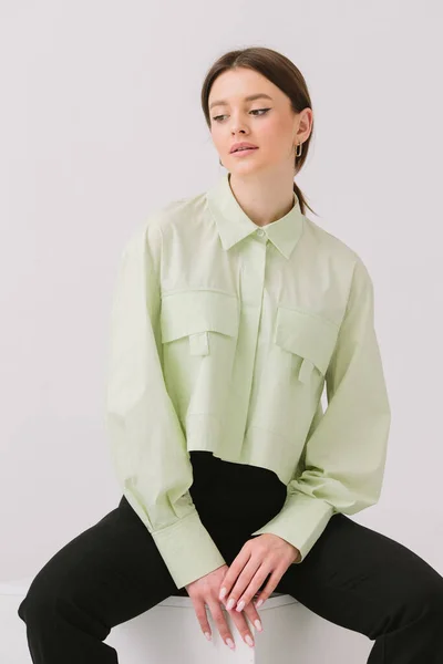 Photo Beautiful Woman Colorful Stylish Shirt Sitting White Cube Isolated — Foto Stock