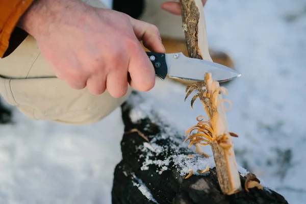 Bir Adam Günbatımında Kış Ormanında Yangın Çıkarmak Için Bir Bıçakla — Stok fotoğraf