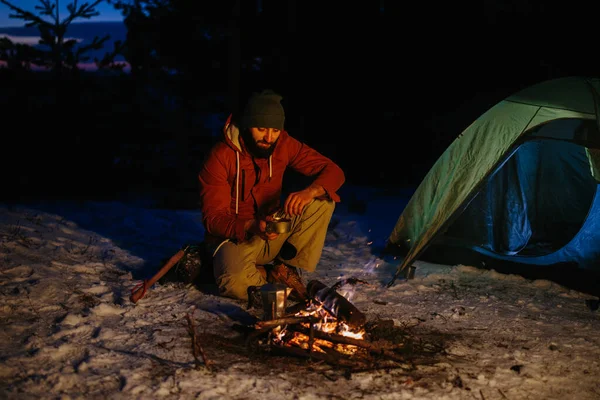 Immagine Giovane Escursionista Che Prepara Cena Vicino Falò Montagna Inverno — Foto Stock