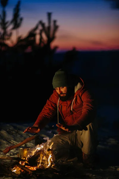 Ein Mann Sitzt Der Nähe Eines Lagerfeuers Und Wärmt Sich — Stockfoto