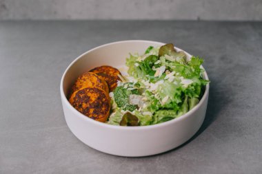 Zarif beyaz tabakta yemek, öğle yemeği ya da akşam yemeği. Lokantada nefis yemekler..