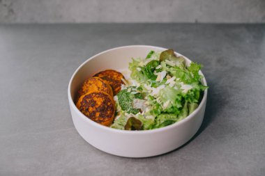 Zarif beyaz tabakta yemek, öğle yemeği ya da akşam yemeği. Lokantada nefis yemekler..