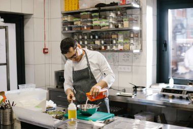 Şef modern ferah mutfakta yemek hazırlıyor..