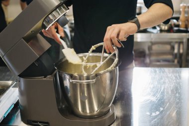 Makaron yapıyorum. Gümüş bir mutfak masası karıştırıcısı hamur yoğurur..