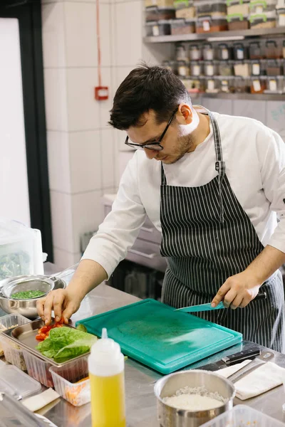 おいしいボウル料理のための野菜の準備 現代的なレストランキッチンの男性シェフ — ストック写真