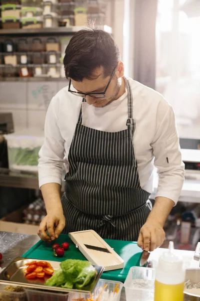 おいしいボウル料理のための野菜の準備 現代的なレストランキッチンの男性シェフ — ストック写真