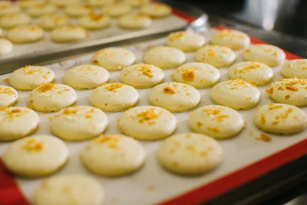 Freshly baked macaroons on a baking sheet.