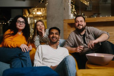 Kafede film izleyen neşeli gençler..