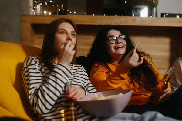 stock image A group of friends watch a comedy movie sitting on soft bean bags with drinks and snacks.