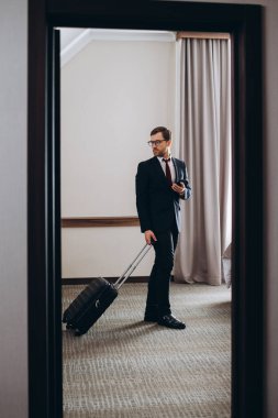 Bavullu bir işadamı otel odasına girer..