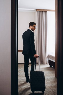 Sabahleyin rahat bir otel odasına resmi giysiler içinde genç ve zarif bir iş gezgini giriyor.