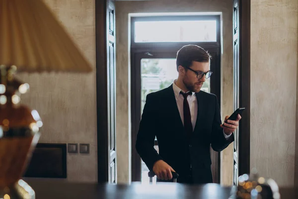 Geschäftsmann Der Mit Koffer Der Hotellobby Spaziert Und Sein Smartphone — Stockfoto