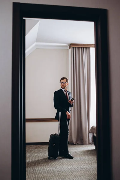 一个带着手提箱的商人走进他的旅馆房间 — 图库照片