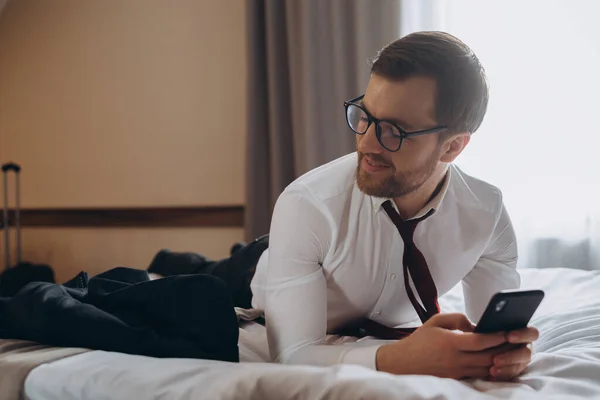ビジネス上のホテルの部屋で電話を使用して陽気なビジネスマントライ — ストック写真