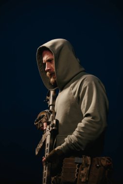 Ukraynalı defans tüfeğini koyu bir arka planda tutuyor.