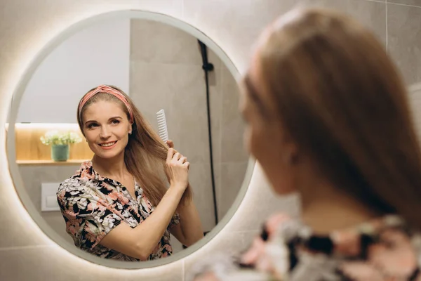 Sorrindo Bonde Menina Pentear Cabelo Frente Espelho — Fotografia de Stock