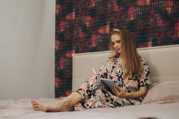 在床上做平板电脑的金发姑娘 — 图库照片