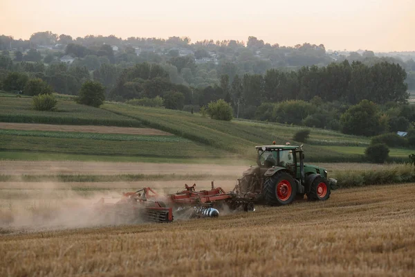 拖拉机在小麦地里犁地 农民的劳动和收获的概念 — 图库照片