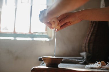 Hamur için yumurta kırıyor. Evde ekmek pişirme süreci..