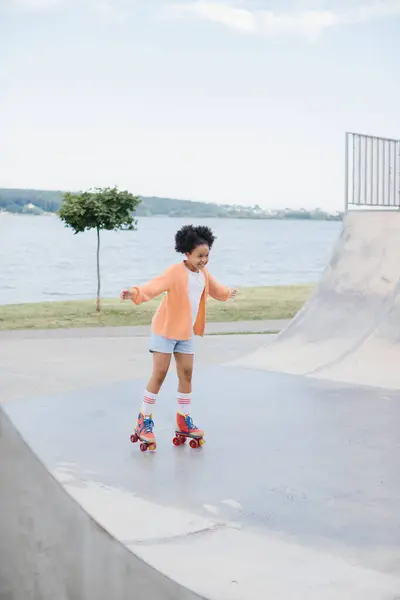 可爱的非洲裔美国小女孩骑在夏季公园的轮滑 孩子们在公园里享受户外运动 小女孩在路上玩旱冰 户外运动学习概念 — 图库照片