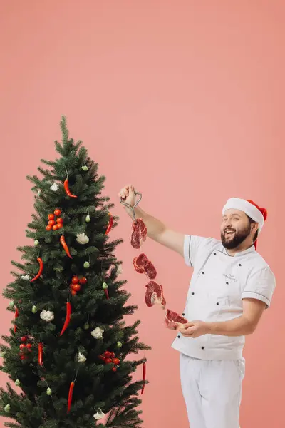 料理とクリスマス休日のコンセプト クリスマスツリーの背景にあるサンタの帽子のシェフ — ストック写真