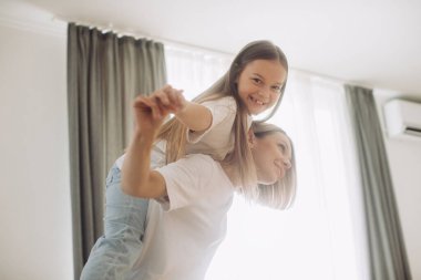 Güzel bir kız bebek ve annesi güneşli bir sabahın tadını çıkarıyorlar. Evde iyi vakit geçir..