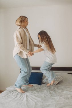 Anne ve küçük kızı evde eğleniyor. Neşeli bir şekilde Çalıyor, Zıplıyor ve Şık Çatı katında bir yatağa düşüyor. Mutlu Çocukluk, Ebeveynlik ve Annelik Anıları.