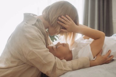 Anne kızıyla birlikte sabahları yatakta eğleniyor.