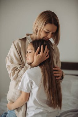 Anneler Günü. Küçük bir kız annesine sevgiyle sarılıyor..