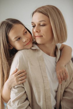 Anneler Günü. Küçük bir kız annesine sevgiyle sarılıyor..