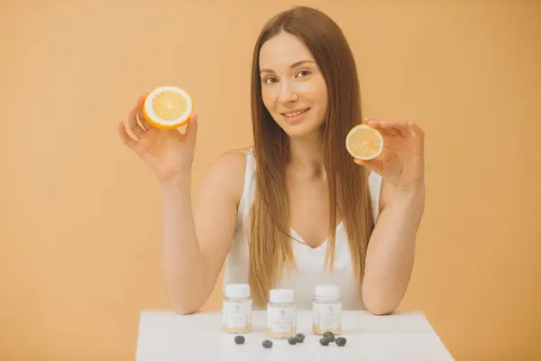 Hermosa Chica Con Una Naranja Fresca Botellas Vitaminas Sobre Fondo —  Fotos de Stock