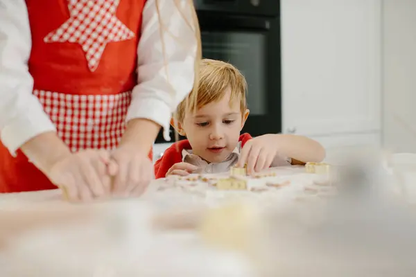 A little boy plays with dough while making cookies in the kitchen. Children make Christmas cookies, Christmas concept.