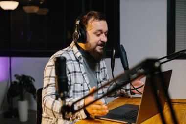 Bir internet blogcusu akarsu sırasında mikrofona konuşuyor. Radyo sunucusu yayın sırasında stüdyoda..
