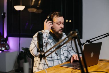 Bir internet blogcusu akarsu sırasında mikrofona konuşuyor. Radyo sunucusu yayın sırasında stüdyoda..