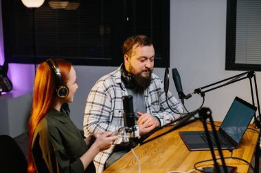 Radyo sunucuları akşam programı sırasında iletişim kuruyor. Ev stüdyosunda yeni bir podcast bölümü kaydediliyor..
