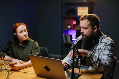 Talk Show sunucuları yeni bir bölüm kaydederken stüdyoda sohbet ediyorlar..