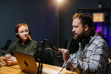 Talk Show sunucuları yeni bir bölüm kaydederken stüdyoda sohbet ediyorlar..
