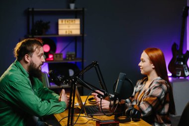 Adam internet yayınında profesyonel mikrofon ve ses karıştırıcı kullanarak kadınla sohbet ediyor. Çevrimiçi radyo istasyonu sunucusu. Gece yarısı talk show 'unda podcast röportajı yapan konuk..