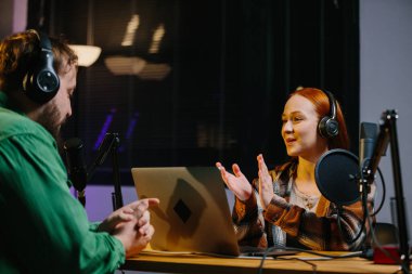 Adam internet yayınında profesyonel mikrofon ve ses karıştırıcı kullanarak kadınla sohbet ediyor. Çevrimiçi radyo istasyonu sunucusu. Gece yarısı talk show 'unda podcast röportajı yapan konuk..