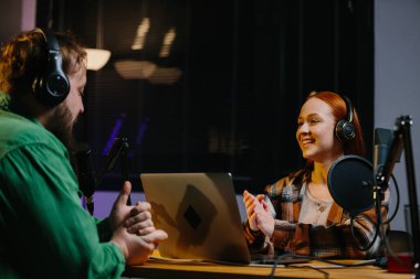 Adam internet yayınında profesyonel mikrofon ve ses karıştırıcı kullanarak kadınla sohbet ediyor. Çevrimiçi radyo istasyonu sunucusu. Gece yarısı talk show 'unda podcast röportajı yapan konuk..