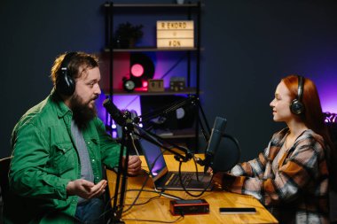 Adam internet yayınında profesyonel mikrofon ve ses karıştırıcı kullanarak kadınla sohbet ediyor. Çevrimiçi radyo istasyonu sunucusu. Gece yarısı talk show 'unda podcast röportajı yapan konuk..