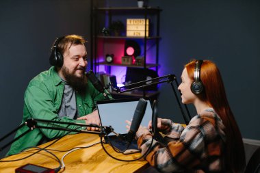 Adam internet yayınında profesyonel mikrofon ve ses karıştırıcı kullanarak kadınla sohbet ediyor. Çevrimiçi radyo istasyonu sunucusu. Gece yarısı talk show 'unda podcast röportajı yapan konuk..