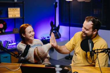 Adam internet yayınında profesyonel mikrofon ve ses karıştırıcı kullanarak kadınla sohbet ediyor. Çevrimiçi radyo istasyonu sunucusu. Gece yarısı talk show 'unda podcast röportajı yapan konuk..
