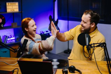 Adam internet yayınında profesyonel mikrofon ve ses karıştırıcı kullanarak kadınla sohbet ediyor. Çevrimiçi radyo istasyonu sunucusu. Gece yarısı talk show 'unda podcast röportajı yapan konuk..