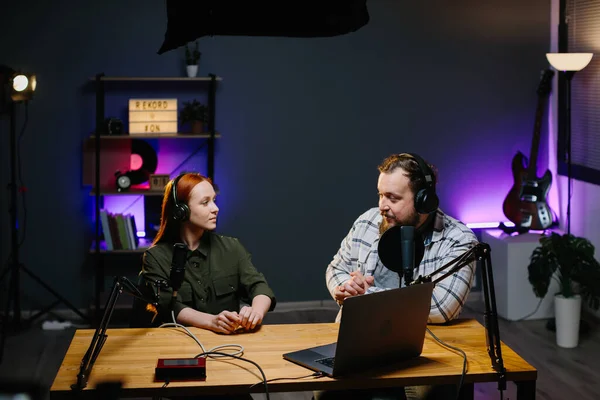Bir internet blogcusu stüdyoda bir misafirle podcast bölümü çekiyor. İçerik yaratıcısı sosyal ağlardan canlı bir konuşma yayınlıyor. Radyo sunucuları stüdyoda canlı yayında..