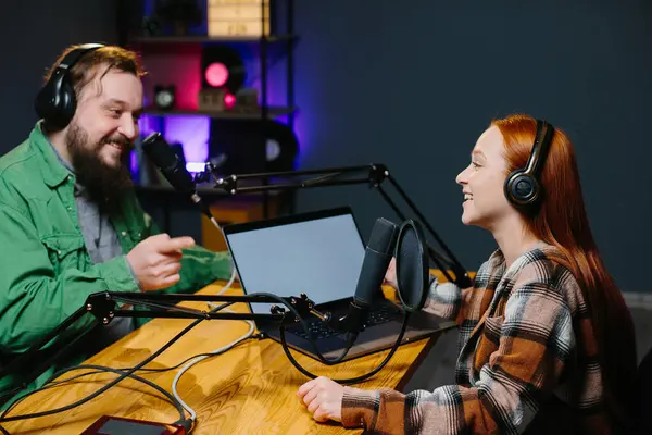 Bir podcast sunucusu ve bir konuk ev stüdyosunda canlı yayında sohbet ederken eğleniyorlar..